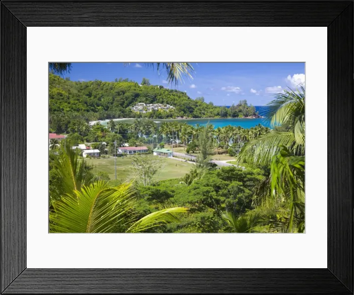 Framed Print : View from hillside across playing field to village and bay, Baie Lazare Framed Print : View from hillside across playing field to village and bay, Baie Lazare