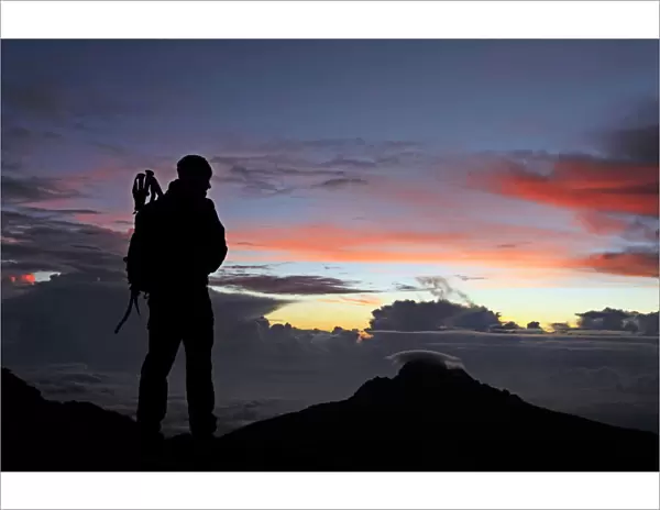 A climber looks towards Mawenzi from near the summit of Mount Kilimanjaro at dawn