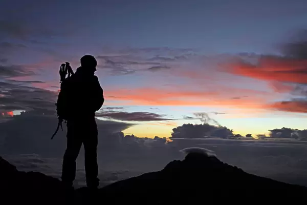 A climber looks towards Mawenzi from near the summit of Mount Kilimanjaro at dawn