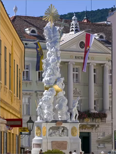 The Trinity Column dating from 1714 and people walking around Hauptplatz surrounded by 18th century buildings, Baden