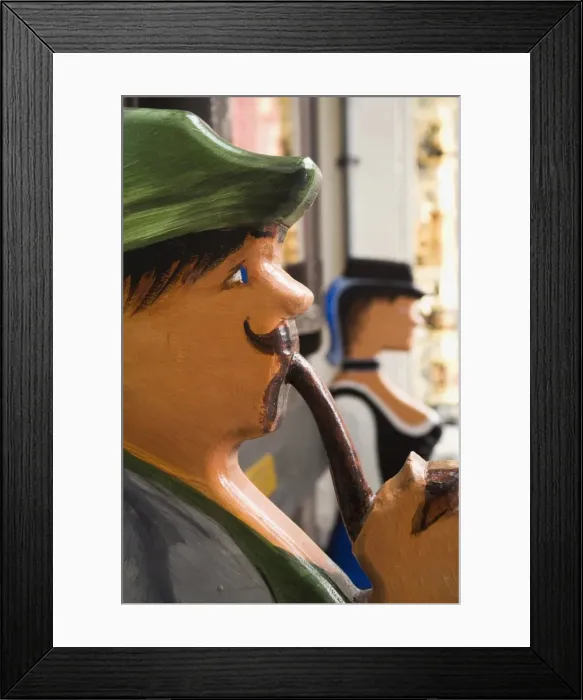 Framed Print : The ends of an ornate bench shaped like a Bavarian man and woman in Garmisch-Partenkirchen Framed Print : The ends of an ornate bench shaped like a Bavarian man and woman in Garmisch-Partenkirchen