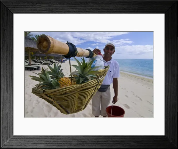 Framed Print : Man selling pineapples on the beach of the Beachcomber Le Paradis five star hotel Framed Print : Man selling pineapples on the beach of the Beachcomber Le Paradis five star hotel