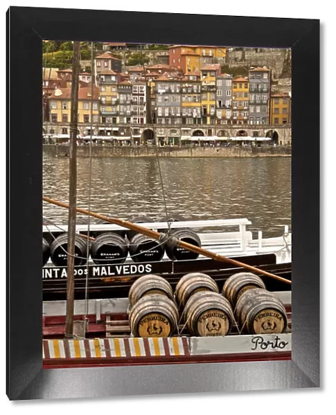 Port wine barrels on a boat on River Douro with Vila Nova de Gaia in the background