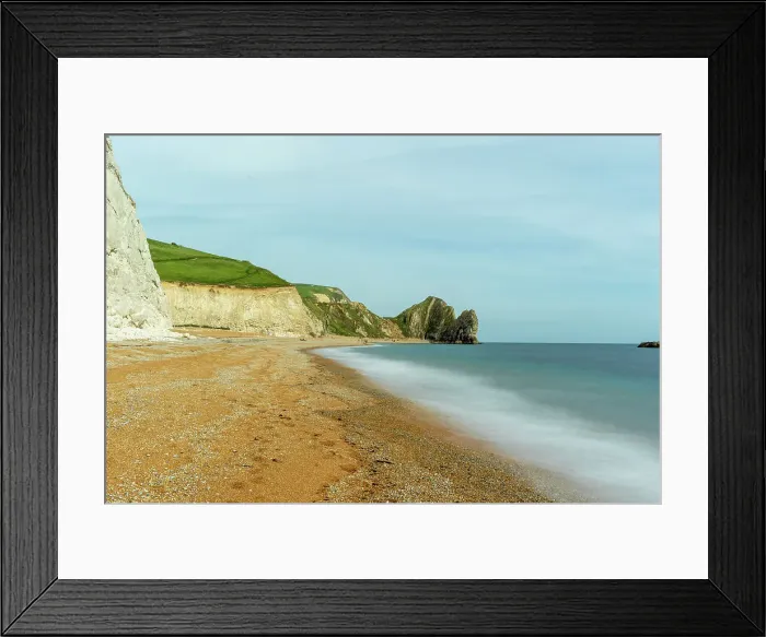 Framed Print : Serene beach with smooth water, sandy shore, and rugged cliffs under a clear sky at Durdle Door, Jurassic Coast, UNESCO World Heritage Site, Dorset, England, United Kingdom, Europe