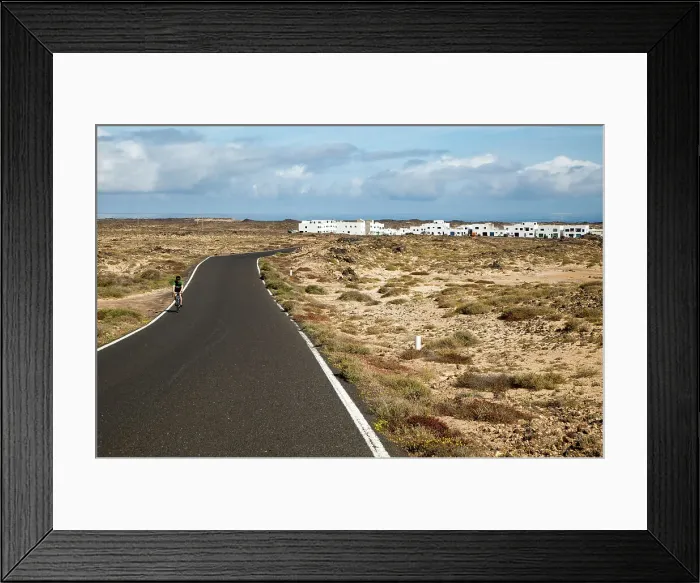 Framed Print : Cyclist on road at Caleta de Caballo village, Lanzarote, Canary islands, Spain, Atlantic, Europe Framed Print : Cyclist on road at Caleta de Caballo village, Lanzarote, Canary islands, Spain, Atlantic, Europe