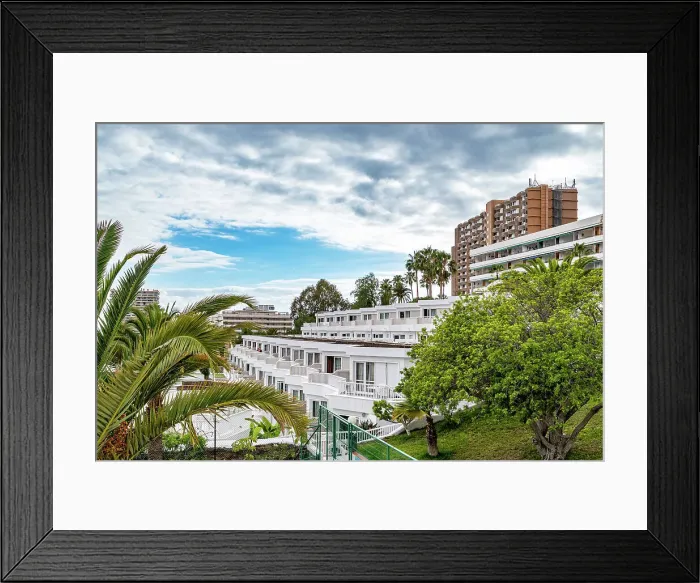 Framed Print : Urban landscape with modern apartment buildings surrounded by lush greenery under a cloudy sky in Los Cristianos, Tenerife, Canary Islands, Spain, Atlantic, Europe Framed Print : Urban landscape with modern apartment buildings surrounded by lush greenery under a cloudy sky in Los Cristianos, Tenerife, Canary Islands, Spain, Atlantic, Europe