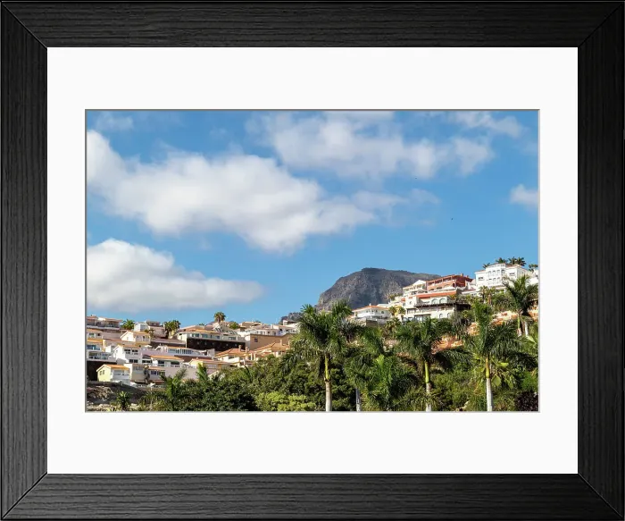 Framed Print : Scenic view of a hillside town with white buildings, lush greenery, and a mountain backdrop under a blue sky at Siam Park in Tenerife, Canary Islands, Spain, Atlantic, Europe Framed Print : Scenic view of a hillside town with white buildings, lush greenery, and a mountain backdrop under a blue sky at Siam Park in Tenerife, Canary Islands, Spain, Atlantic, Europe