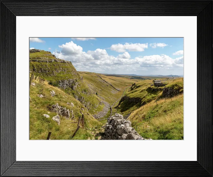 Framed Print : Scenic view of a lush green valley with rocky outcrops under a blue sky with clouds, showcasing natural beauty and tranquility at Malham Cove, Yorkshire, England, United Kingdom, Europe Framed Print : Scenic view of a lush green valley with rocky outcrops under a blue sky with clouds, showcasing natural beauty and tranquility at Malham Cove, Yorkshire, England, United Kingdom, Europe