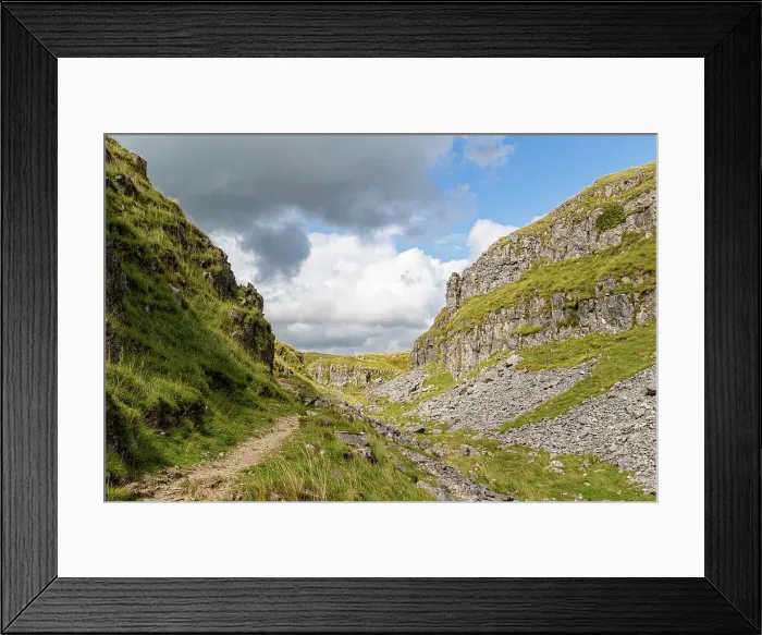 Framed Print : Scenic view of a mountain path with lush greenery under a cloudy sky at Malham Cove, Yorkshire, England, United Kingdom, Europe Framed Print : Scenic view of a mountain path with lush greenery under a cloudy sky at Malham Cove, Yorkshire, England, United Kingdom, Europe