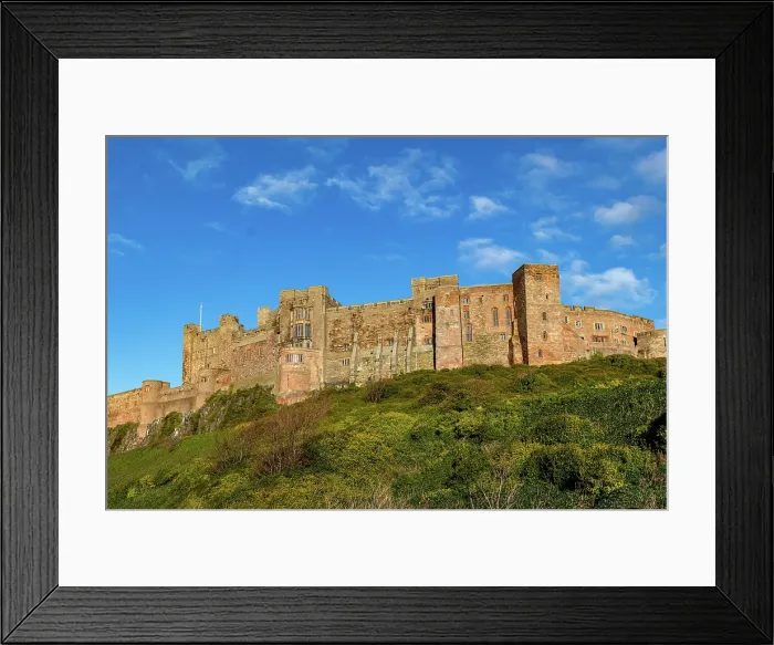 Framed Print : Majestic medieval castle on a hill with lush greenery under a clear blue sky, Bamburgh, Northumberland, England, United Kingdom, Europe Framed Print : Majestic medieval castle on a hill with lush greenery under a clear blue sky, Bamburgh, Northumberland, England, United Kingdom, Europe