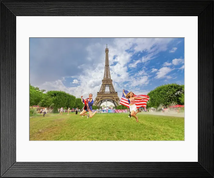 Framed Print : Patriotic American Woman jumping and cheering for Team USA and the Paris 2024 Olympics in front of the Eiffel Tower beach volleyball stadium, Paris, France, Europe Framed Print : Patriotic American Woman jumping and cheering for Team USA and the Paris 2024 Olympics in front of the Eiffel Tower beach volleyball stadium, Paris, France, Europe