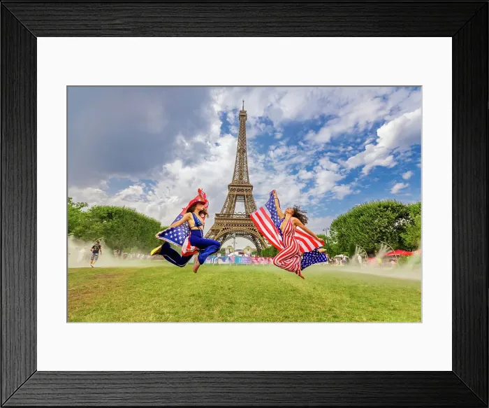 Framed Print : Patriotic American Woman jumping and cheering for Team USA and the Paris 2024 Olympics in front of the Eiffel Tower beach volleyball stadium, Paris, France, Europe