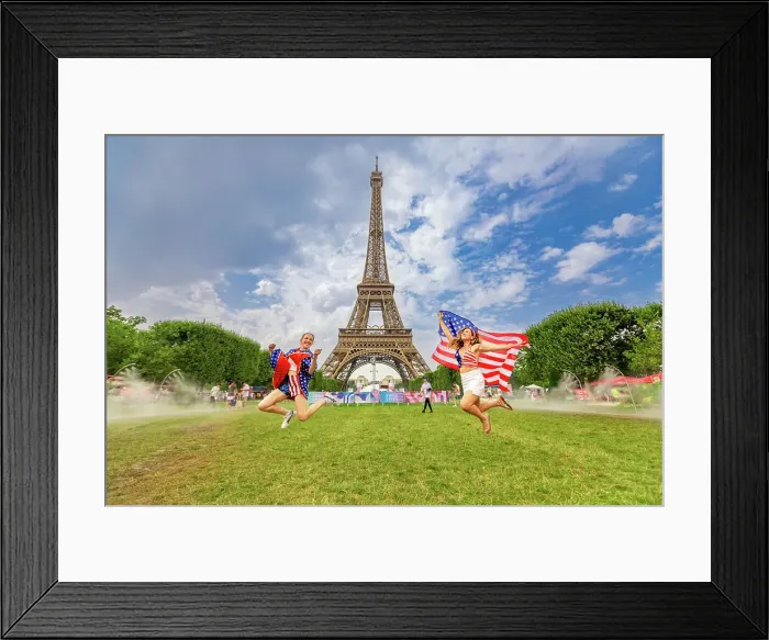 Framed Print : Patriotic American Woman jumping and cheering for Team USA and the Paris 2024 Olympics in front of the Eiffel Tower beach volleyball stadium, Paris, France, Europe Framed Print : Patriotic American Woman jumping and cheering for Team USA and the Paris 2024 Olympics in front of the Eiffel Tower beach volleyball stadium, Paris, France, Europe