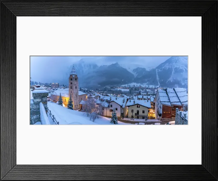Framed Print : View of Church of Saint Pantalon and the snow covered town centre and mountainous background in winter, Courmayeur, Aosta Valley, Italy