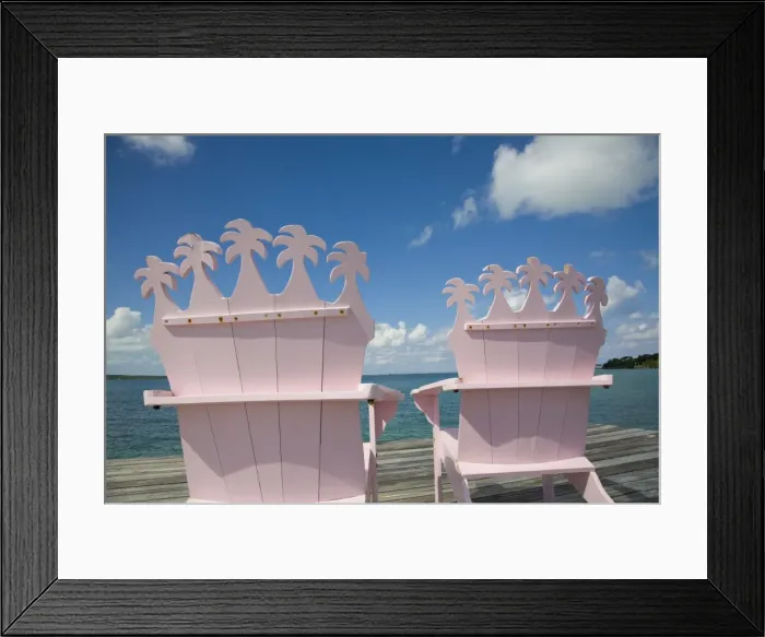 Framed Print : Wooden pink beach chairs with backs carved in the shape of palm trees Framed Print : Wooden pink beach chairs with backs carved in the shape of palm trees