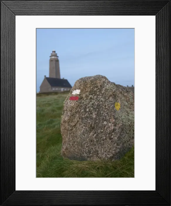 Framed Print : Markings on rock for cross country walkers, and lighthouse in the background Framed Print : Markings on rock for cross country walkers, and lighthouse in the background