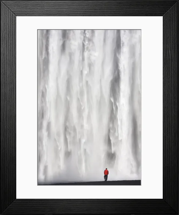 Framed Print : Man in red jacket standing in front of the 62m high Skogafoss waterfall near the village of Skogar Framed Print : Man in red jacket standing in front of the 62m high Skogafoss waterfall near the village of Skogar
