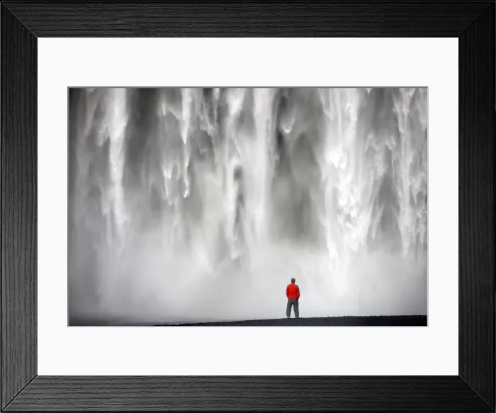 Framed Print : Man in red jacket standing in front of the 62m high Skogafoss waterfall near the village of Skogar Framed Print : Man in red jacket standing in front of the 62m high Skogafoss waterfall near the village of Skogar