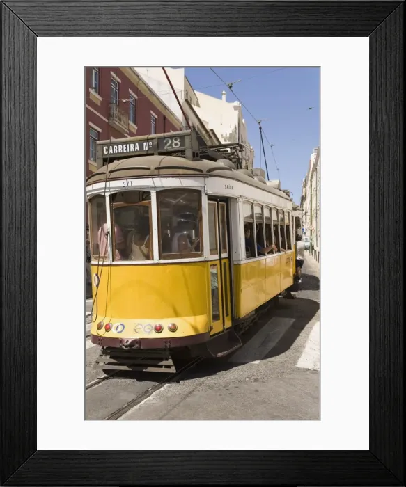 Framed Print : A number 28 tram runs along the scenic route popular with tourists in the Alfama district of Lisbon Framed Print : A number 28 tram runs along the scenic route popular with tourists in the Alfama district of Lisbon