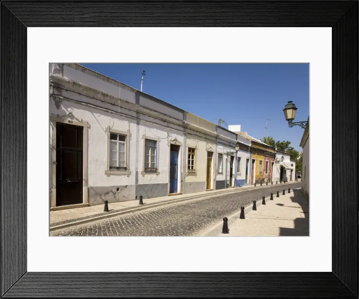 Framed Print : A row of traditional cottages front a cobbled street in the walled town of Faro Framed Print : A row of traditional cottages front a cobbled street in the walled town of Faro