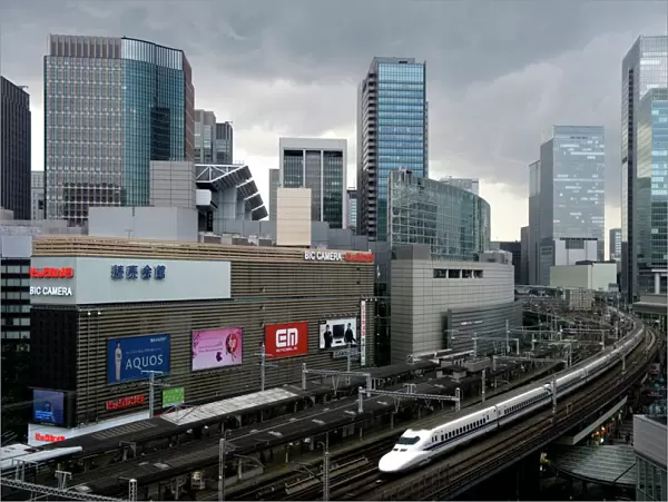 Shinkansen bullet train weaving through maze of buildings in the Yurakucho district of downtown Tokyo