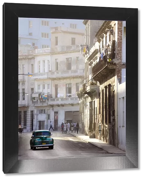Old American car driving along quiet street in Havana Centro, Havana, Cuba
