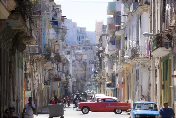 View along congested street in Havana Centro showing people walking along pavements