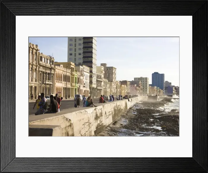 Framed Print : View along The Malecon showing people sitting on the seawall enjoying the evening sunshine