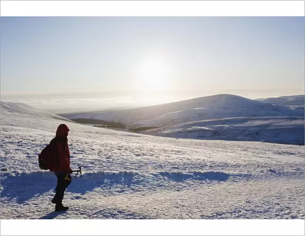 Hiker on snow covered Pen y Fan mountain, Brecon Beacons National Park