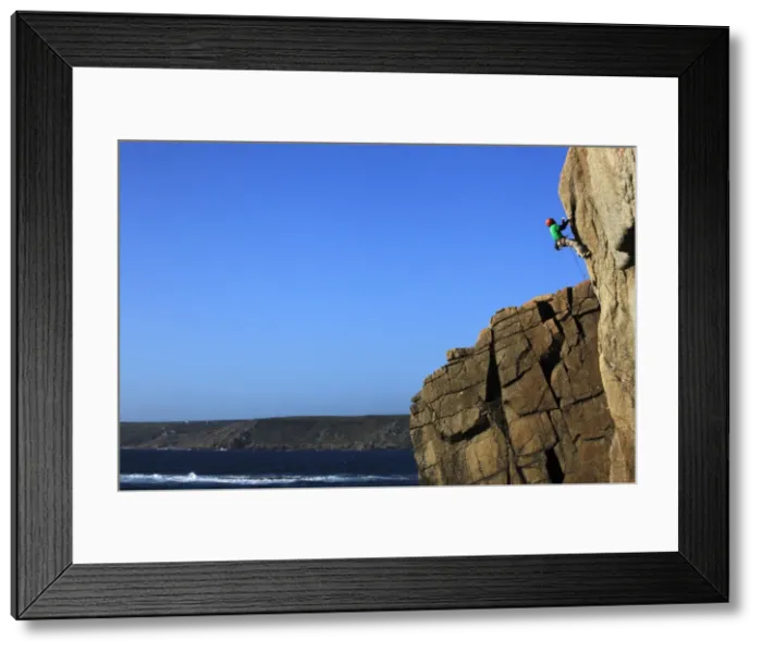 Framed Print : A climber tackles a difficult route on the cliffs near Sennen Cove, a popular rock climbing area at Lands End, Cornwall, England, United Framed Print : A climber tackles a difficult route on the cliffs near Sennen Cove, a popular rock climbing area at Lands End, Cornwall, England, United
