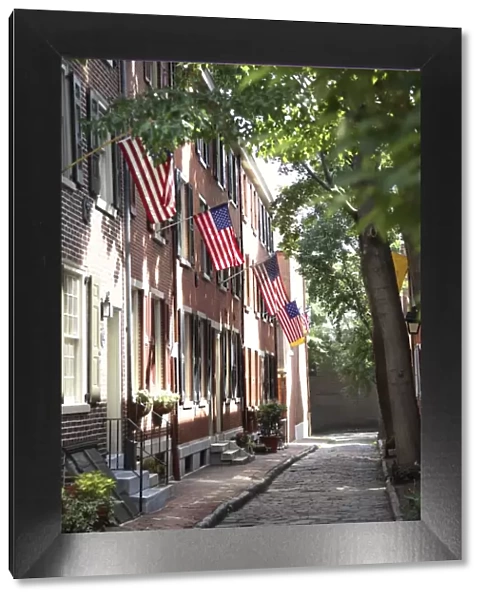Flags displayed on homes on cobblestone American Street, in the Society Hill neighborhood of Philadelphia, Pennsylvania, United States of America