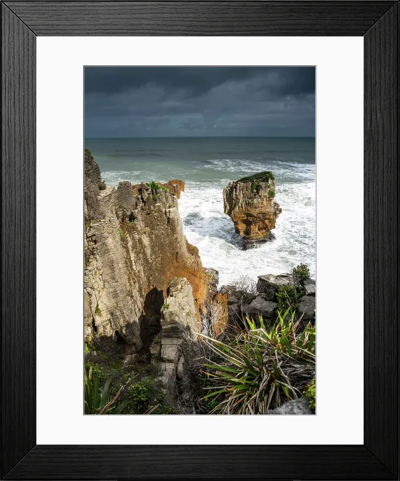 Framed Print : Vertical View of Pancake Rocks and Surf Below with Flax and Cliffside Vegetation in Punakaiki, New Zealand Framed Print : Vertical View of Pancake Rocks and Surf Below with Flax and Cliffside Vegetation in Punakaiki, New Zealand
