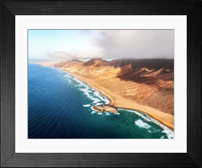 Framed Print : Aerial view of the wild Cofete beach in between volcanic mountains and sea, Jandia Natural Park, Fuerteventura, Canary Islands Framed Print : Aerial view of the wild Cofete beach in between volcanic mountains and sea, Jandia Natural Park, Fuerteventura, Canary Islands