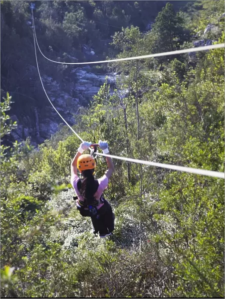Woman sliding down a zip-line, Storms River, Eastern Cape, South Africa, Africa