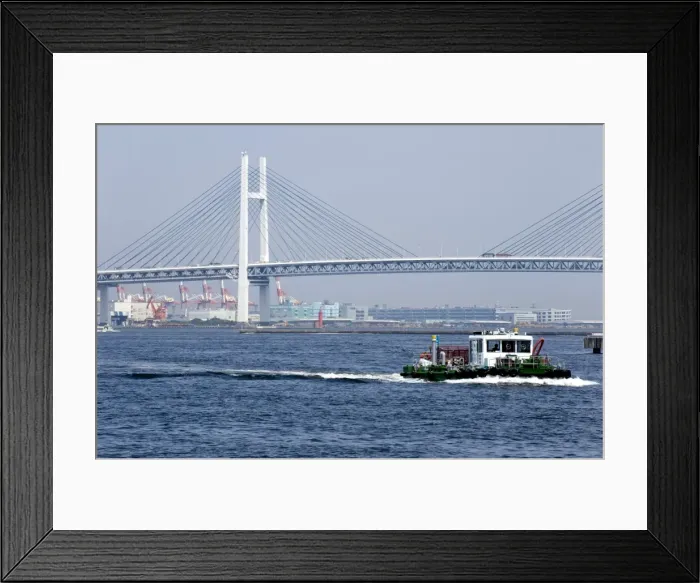 Framed Print : Tug boat passing by the Yokohama Bay Bridge which spans the Tokyo Bay in Yokohama Framed Print : Tug boat passing by the Yokohama Bay Bridge which spans the Tokyo Bay in Yokohama