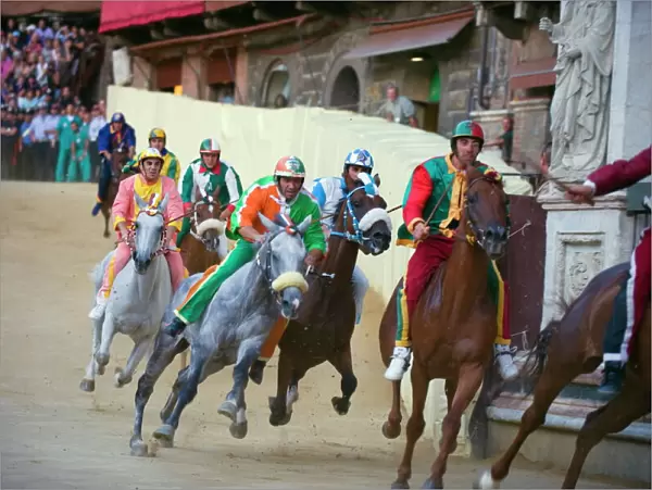 Riders racing at El Palio horse race festival, Piazza del Campo, Siena