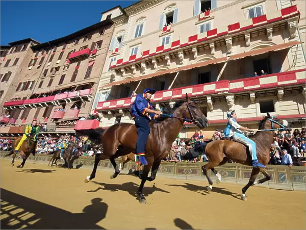 Riders racing at El Palio horse race festival, Piazza del Campo, Siena