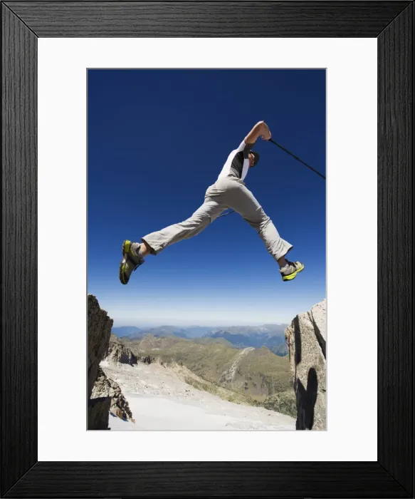 Framed Print : Hiker jumping across a gap in the rocks, Pico de Aneto, the highest peak in the Pyrenees Framed Print : Hiker jumping across a gap in the rocks, Pico de Aneto, the highest peak in the Pyrenees