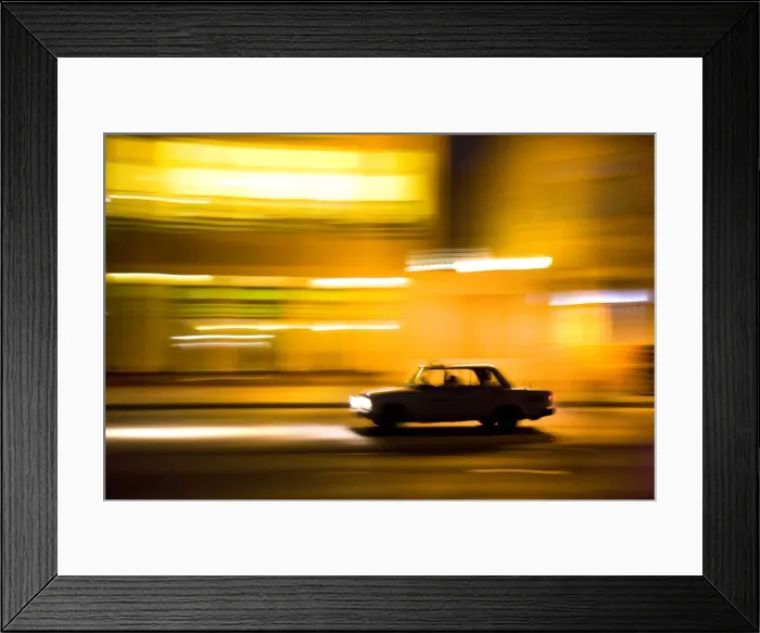Framed Print : Panned shot of car at night passing illuminated buildings on The Malecon Framed Print : Panned shot of car at night passing illuminated buildings on The Malecon