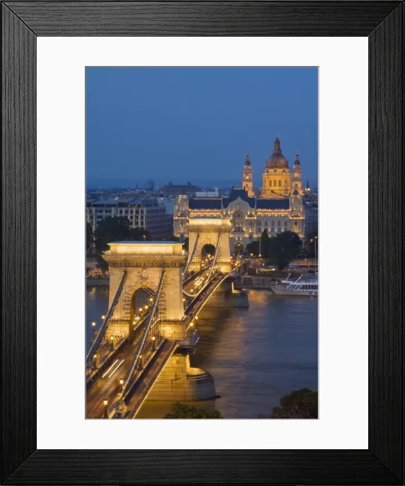 Framed Print : Night view of the Chain Bridge (Szechenyi Lanchid), illuminated, over the River Danube with the Gresham Hotel, St. Stephens basilica, and the Pest side behind, Budapest