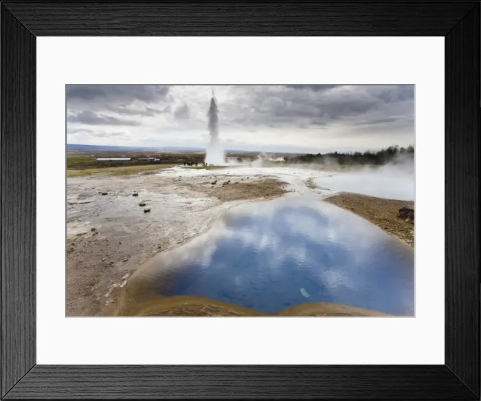 Framed Print : Blue water in geothermal pool with water spout from Strokkur Geysir visible in the distance