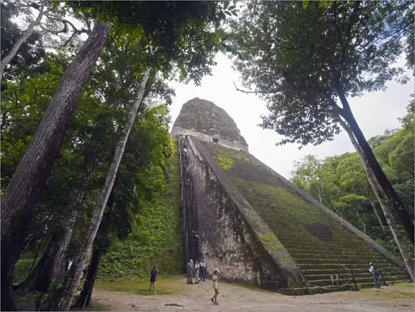 Tourists climbing a pyramid in the forest, Mayan ruins, Tikal, UNESCO World Heritage Site