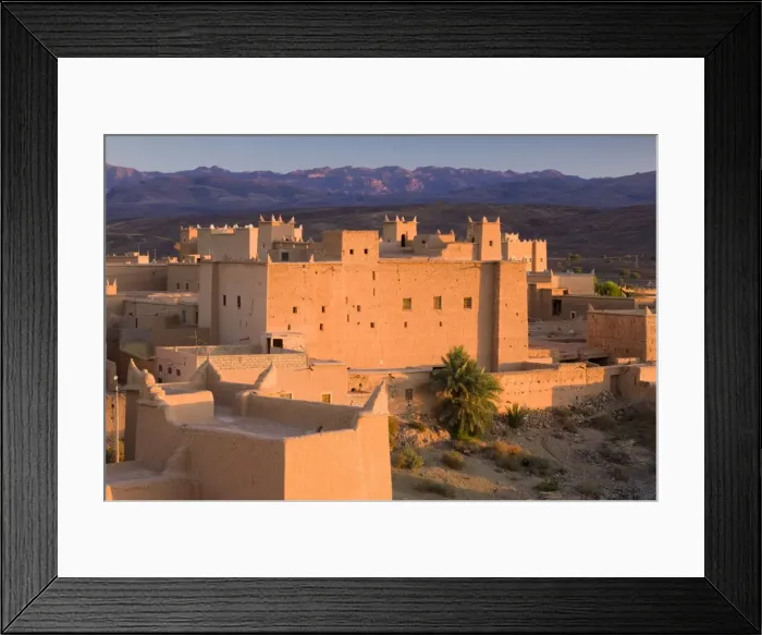 Framed Print : Kasbah bathed in evening light with the Jbel Sarhro Mountains in the distance Framed Print : Kasbah bathed in evening light with the Jbel Sarhro Mountains in the distance