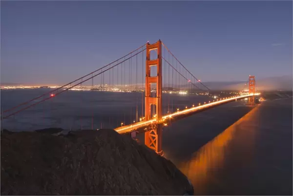 Golden Gate Bridge glowing at sunset with the San Francisco skyline behind
