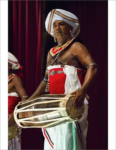 Drummer in a Pancha Thuryas Kandyan dance orchestra at tourist show in the Kandyan Arts Association Hall, Kandy, Sri