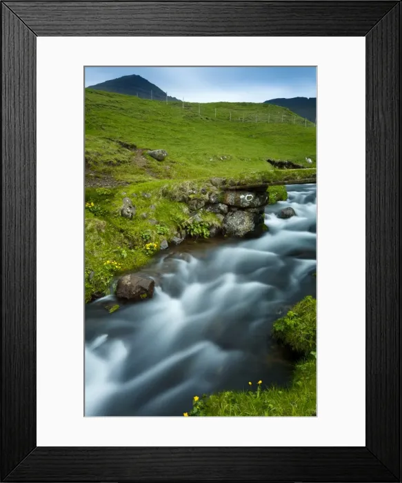 Framed Print : A stream running through the picturesque village of Gasadalur, which is overlooked by the 612m Heinanova mountain, Gasadalur, Vagar Island, Faroe Islands Framed Print : A stream running through the picturesque village of Gasadalur, which is overlooked by the 612m Heinanova mountain, Gasadalur, Vagar Island, Faroe Islands