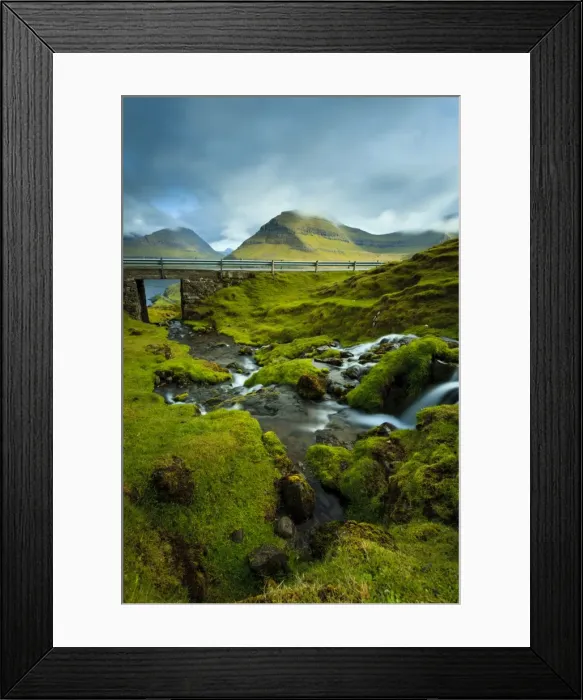 Framed Print : A waterfall cascading down the rocks towards the picturesque village of Funningur