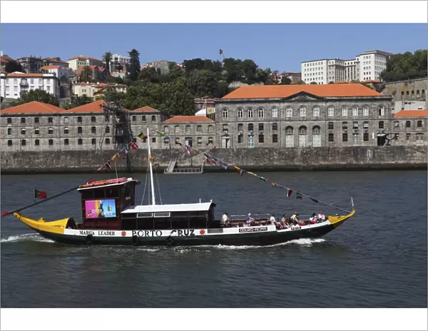 A wooden barcos rabelos boat, once used of delivering wine casks, cruises on the River Douro at Porto, Douro