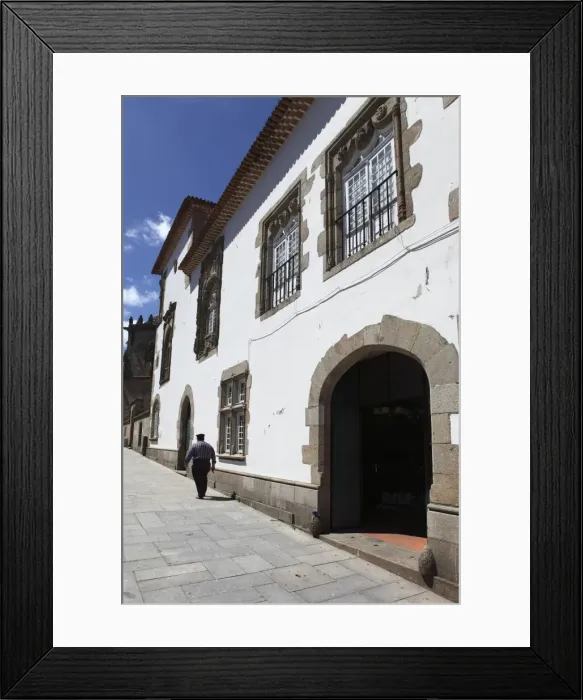 Framed Print : A man walks past the Manueline Coimbras House (Casa dos Coimbras) at Santa Cruz square Framed Print : A man walks past the Manueline Coimbras House (Casa dos Coimbras) at Santa Cruz square