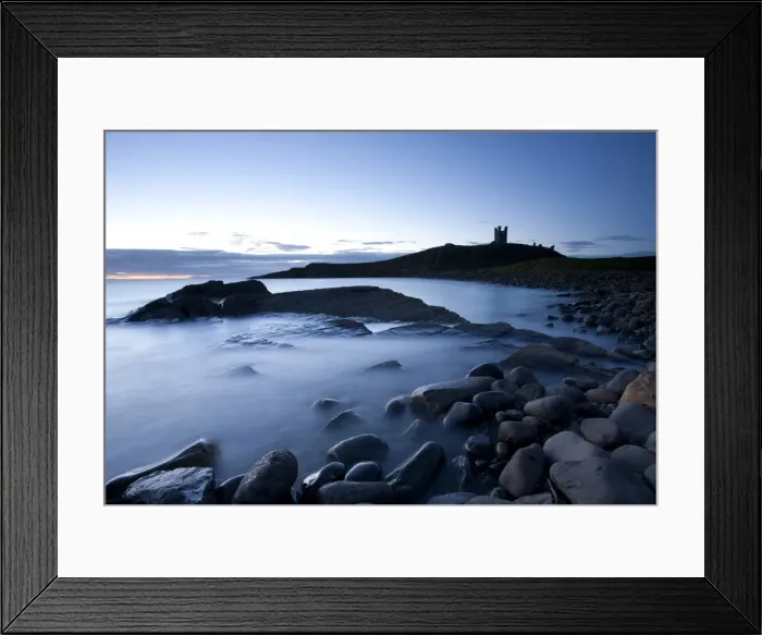 Framed Print : The ruins of Dunstanburgh Castle at dawn with Greymare Rock partly sumberged Framed Print : The ruins of Dunstanburgh Castle at dawn with Greymare Rock partly sumberged